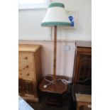 A 1930's walnut veneered standard lamp with shelf