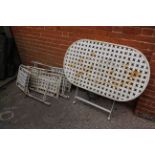 A white metal garden table and four chairs