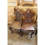 A pair of Victorian carved oak hall chairs