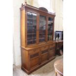 A substantial Edwardian American walnut glazed cupboard bookcase with brass inscribed plaque,