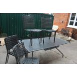 A large dark grey metal extending garden table and ten chairs