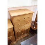 A modern pine three drawer combination chest with two door cupboard below