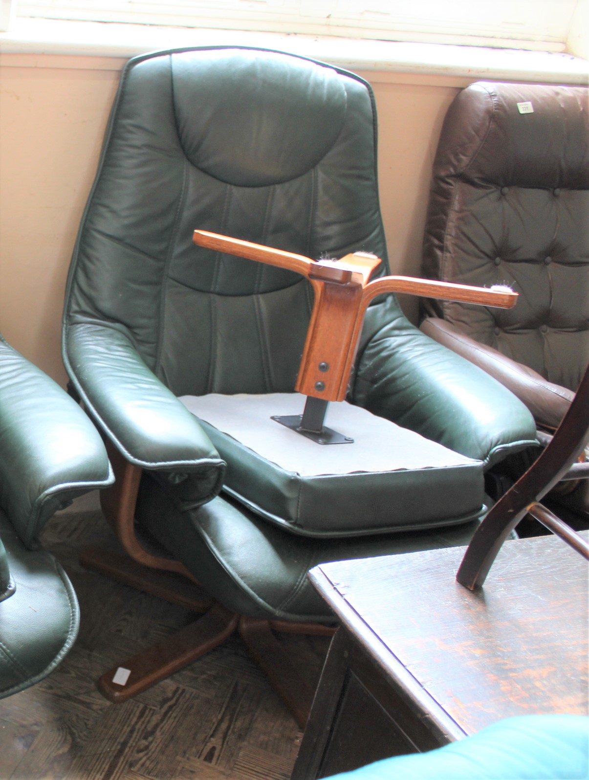 A green leather Stressless style reclining armchair with matching foot stool