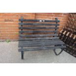 A teak and black iron garden bench of small proportions