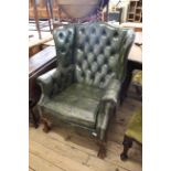 A Victorian style green leather button back wing armchair