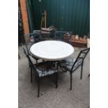 A black metal circular garden table with four chairs