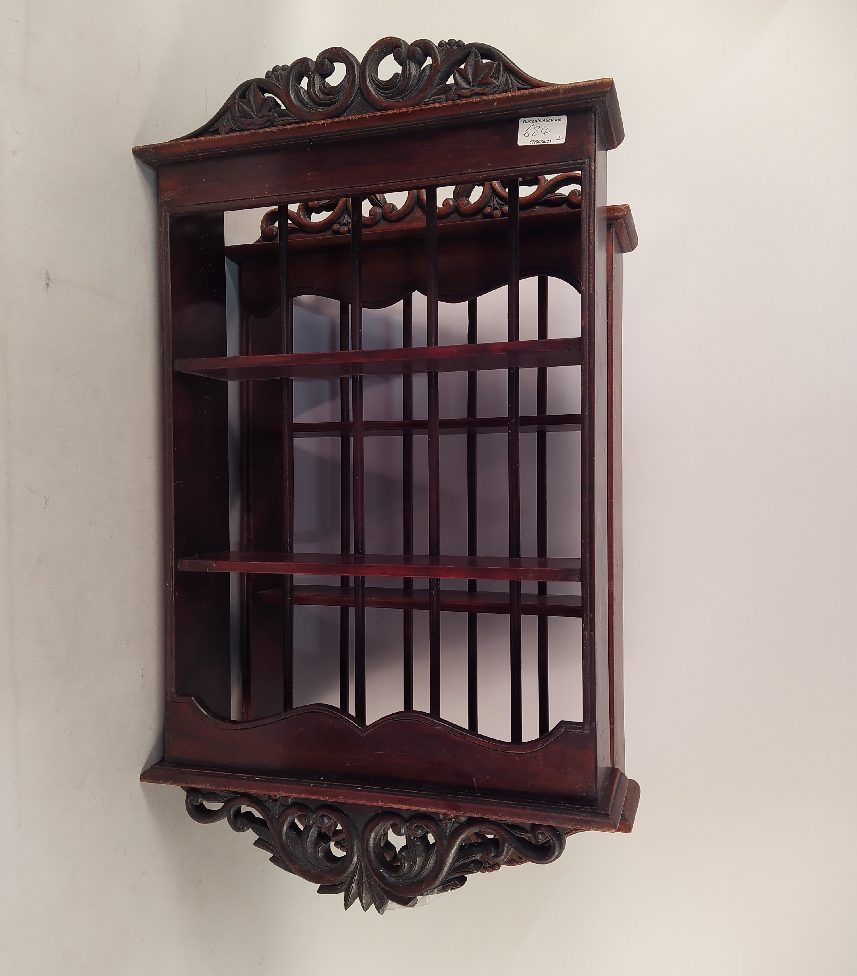 A pair of small mahogany hanging shelves with carved pierced cresting