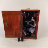 A mid century wooden boxed microscope marked C Baker 32420 London with various extra lenses