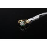 An 18ct gold emerald and single diamond set ring, size N,