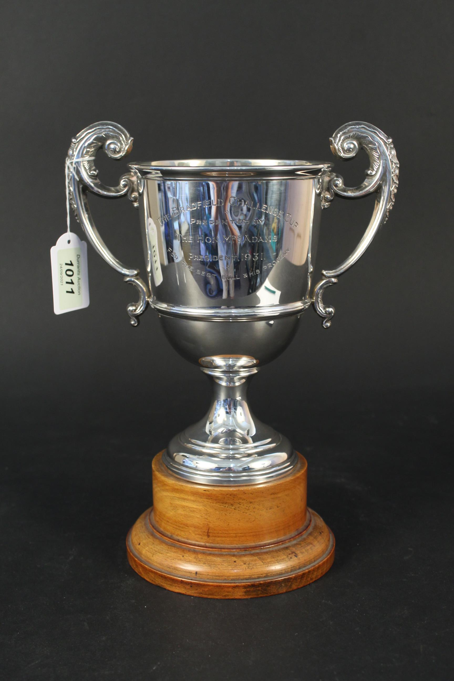 A silver two handled trophy cup with presentation inscription with wooden base,