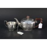 A silver teapot and matching sugar bowl,