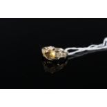 A 9ct gold ring with central citrine in raised four claw setting with green stone set shoulders,