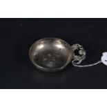 A silver wine taster with leaf and vine handle,