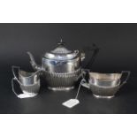 A three piece silver tea set of half fluted design, hallmarked Sheffield 1897,