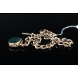 A large 9ct gold watch chain with t-bar and dog clip suspending a 9ct gold stone set swivel fob,