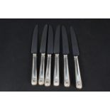 A set of six silver handled shell pattern dinner knives,