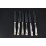 A set of six silver handled shell pattern side knives,