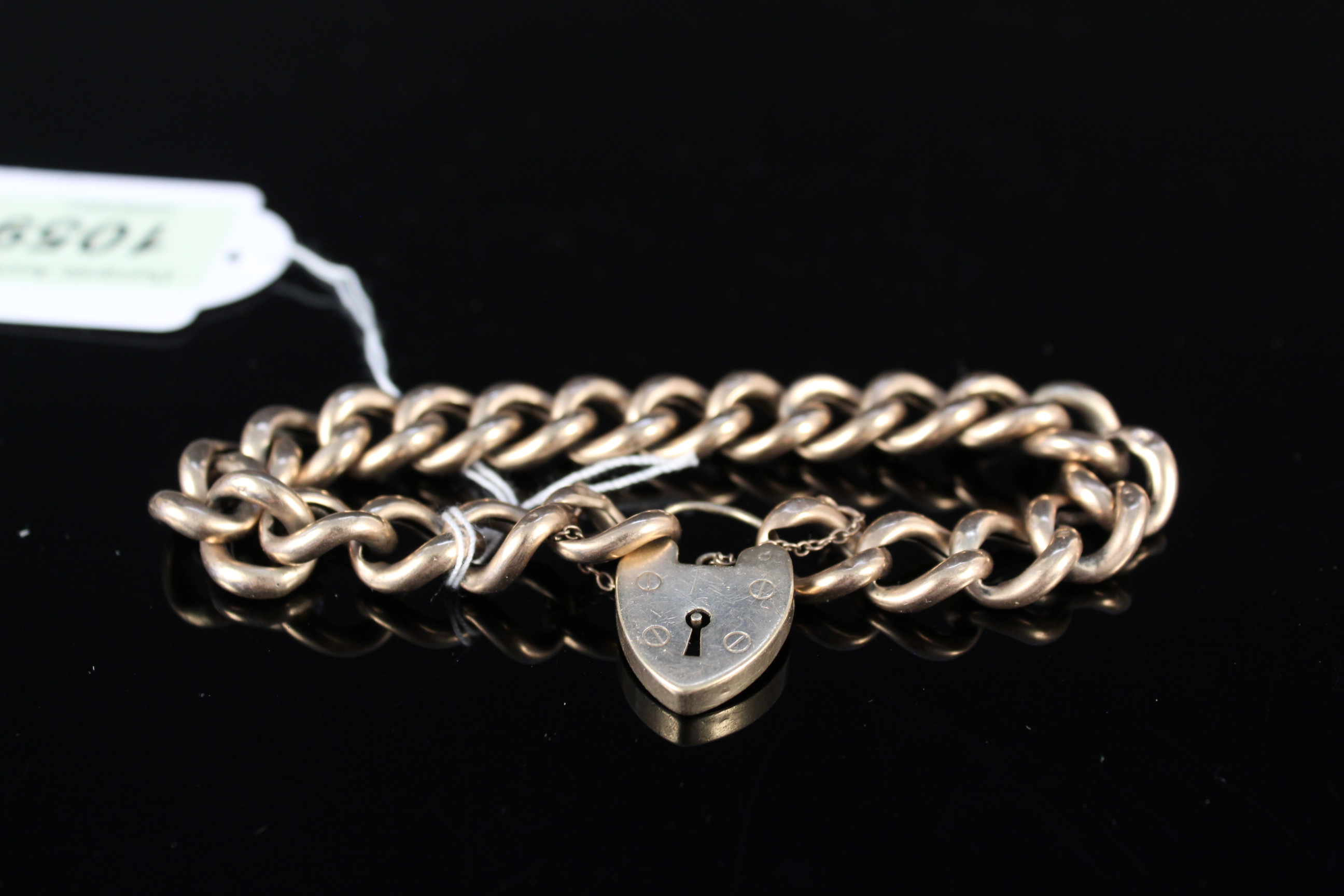 A 9ct gold curb link bracelet (as found) with heart shaped padlock clasp,