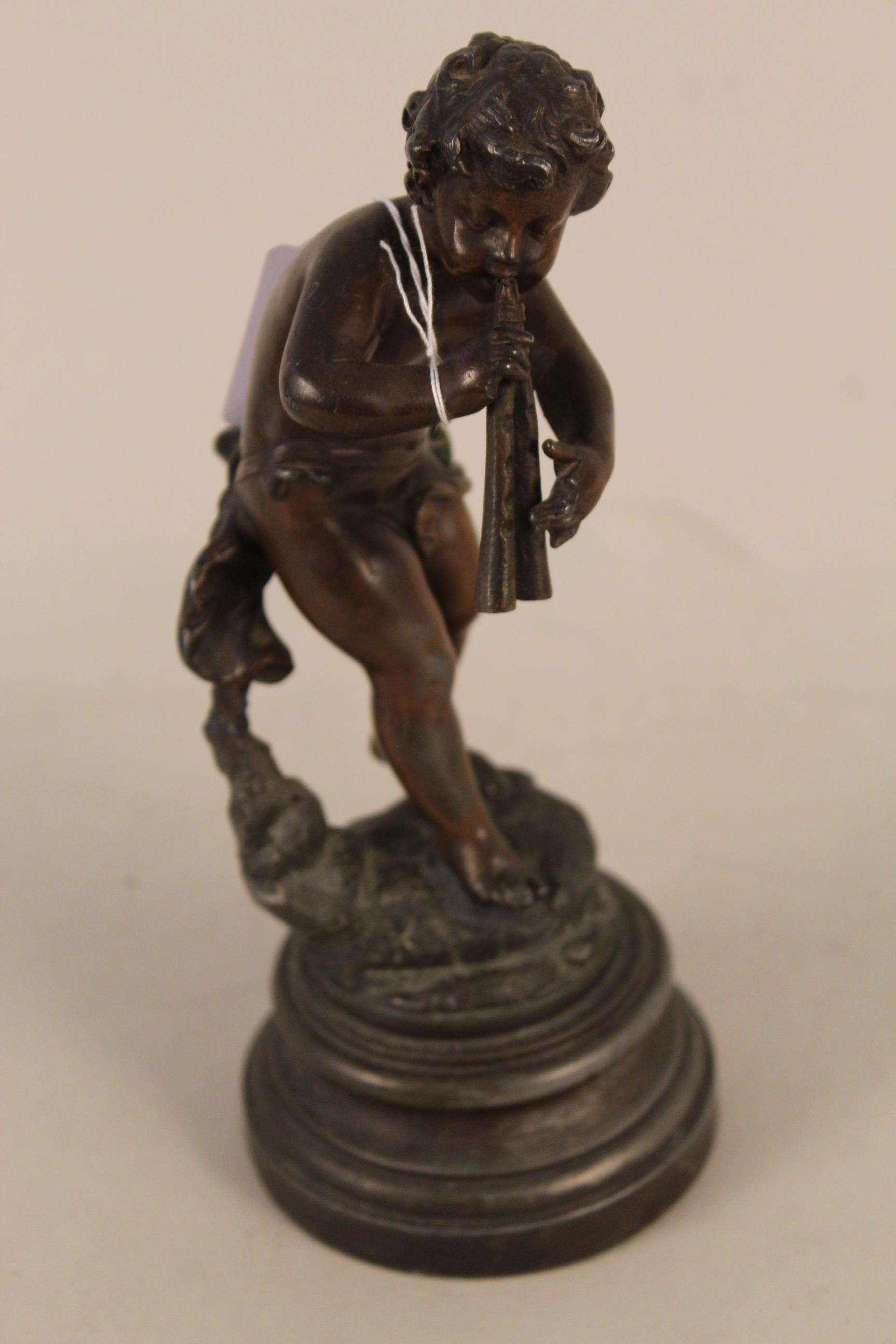 A vintage bronze figurine of Pan playing flute, marked France to base, mounted on a spelter base,