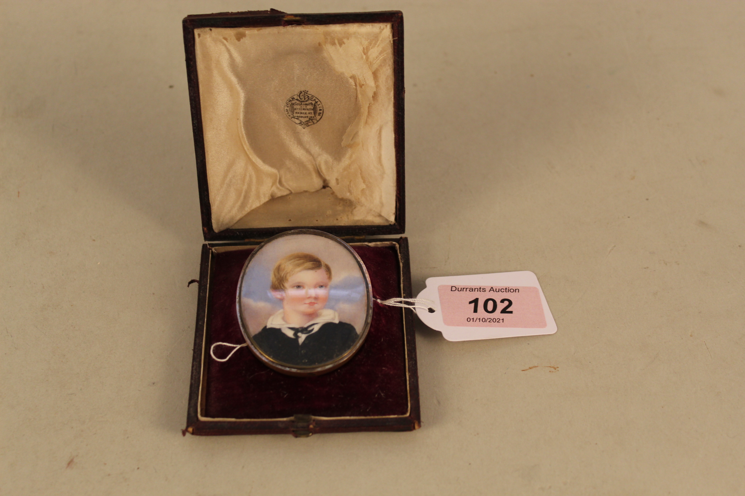 A 19th Century miniature watercolour of a young boy in period leather case