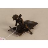 A late bronze cupid figure seated on a rug, marked Ferrand for Ernst Justin Ferrand,