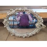 An oval mirror with painted frame 26" long