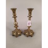 A pair of 18th Century Spanish brass candlesticks with knopped stems and shaped seven sided bases