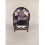 An Art Nouveau style white metal oval framed mirror,