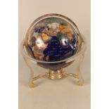 An Oriental stone set globe on stand with integral compass,