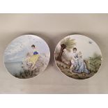 A pair of continental porcelain dishes with painted portraits depicting a mother with children and