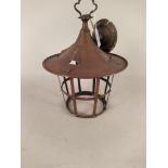 An Arts and Crafts copper lantern of tapering circular form with over hanging canopy,