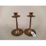 A pair of Arts and Crafts bronze candlesticks marked Dryad Leicester,