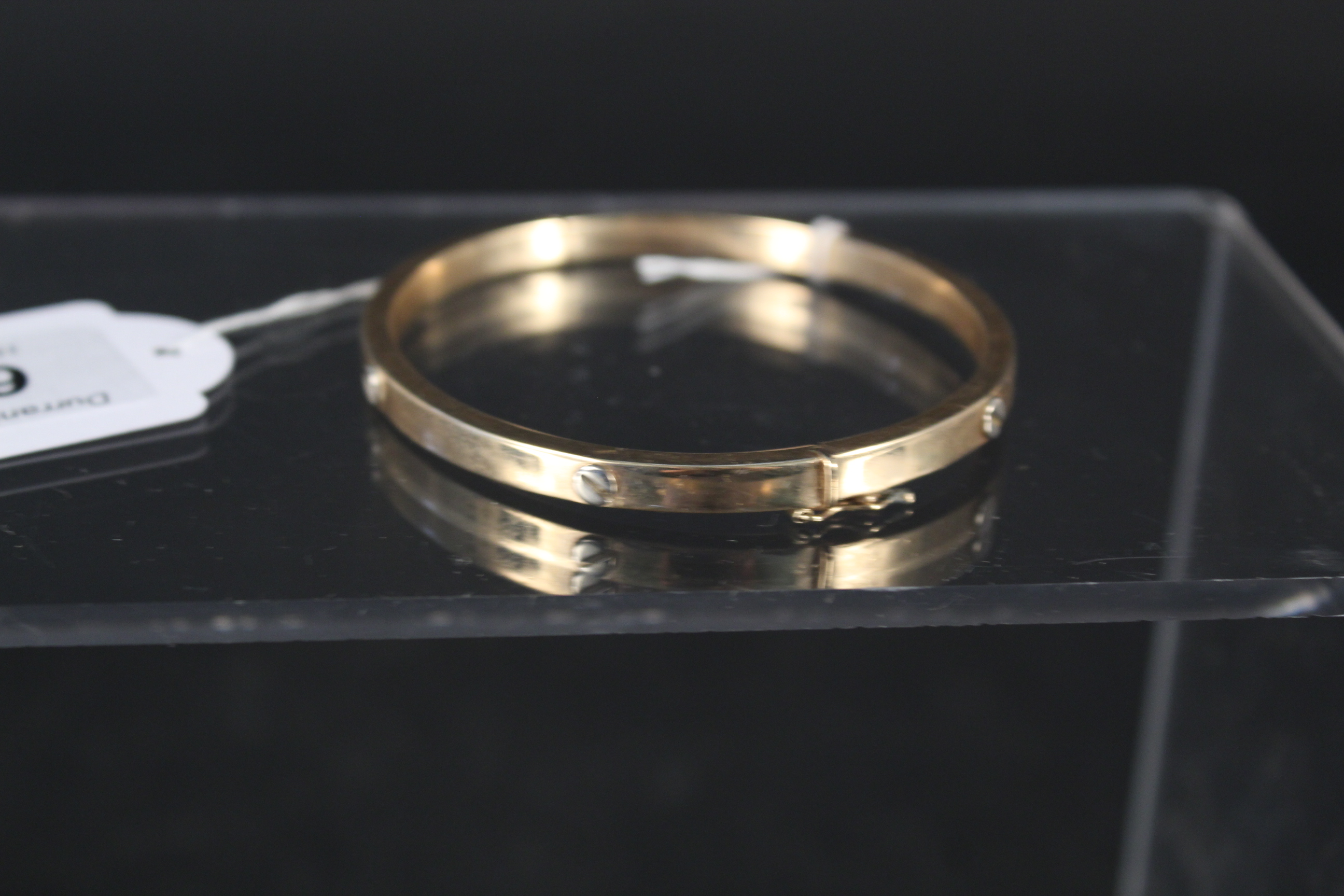 A 9ct gold bangle with 'screw' form decoration, weight approx 10.