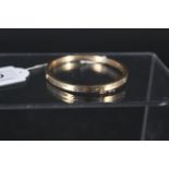 A 9ct gold bangle with 'screw' form decoration, weight approx 10.