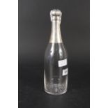 An antique glass and silver champagne bottle form decanter with glass stopper (hinge is as found),