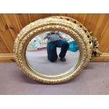 Two round and one oval gilt framed mirrors,