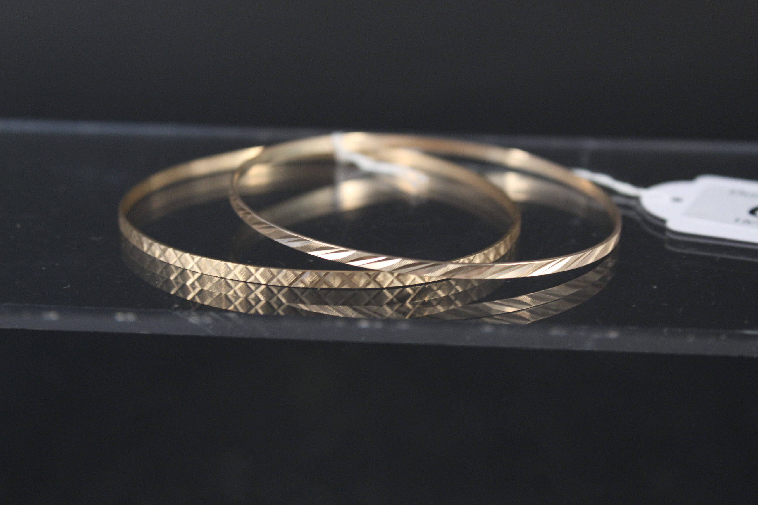 Two 9ct gold bangles with engraved decoration, weight approx 8.
