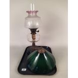 An Art Nouveau style oil lamp with ceramic base, copper central support, clear glass reserve,