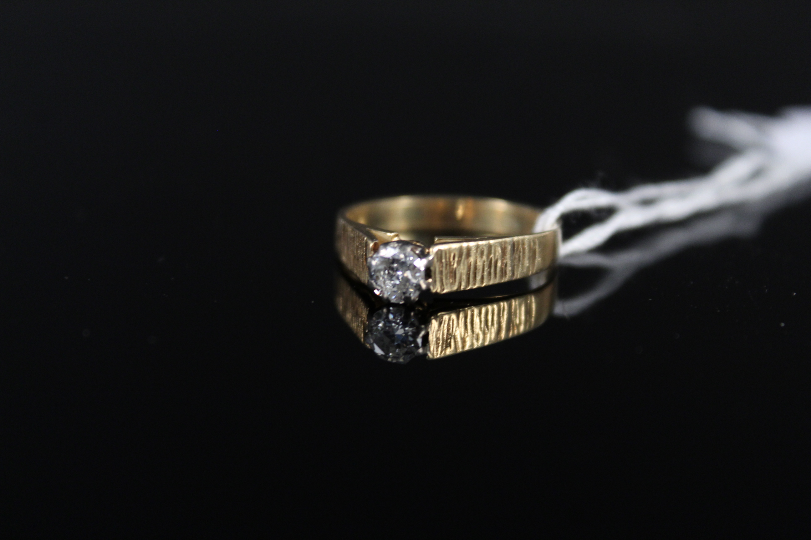 An 18ct gold solitaire ring with bark effect shoulders, size L, weight approx 2.