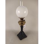 A duplex oil lamp with brass reserve, spelter base, shade and funnel,
