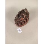 A Victorian oval copper jelly mould with fluted surround below an eight pointed turret top by