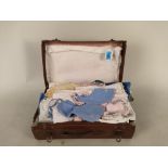 A small suitcase full of vintage dolls clothes,