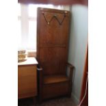 An unusual 1930's oak high back hall seat with later added coat hooks