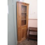 A modern pine corner cupboard with glazed top