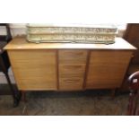 A 1970's Alfred Cox teak sideboard with two cupboards and three central drawers on four angled legs