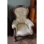 A mid Victorian walnut framed gentleman's armchair with carved arm scrolls and carved cabriole legs