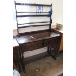 An Ercol style stained elm small cottage dresser with rack and standing on four turned legs with
