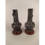A pair of late 19th Century spelter vases on marble bases with raised decoration emblematic of