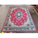 An Egyptian oriental style rug with central medallion on a red ground,