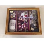 A table top display cabinet and contents including lighters, banknotes, buttons etc,